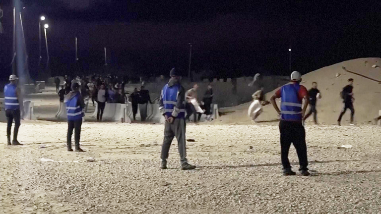 Gunfire can be heard as Palestinians run towards aid being distributed. Pic: AP