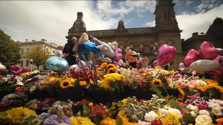 Members of the public leave flowers at a memorial site for the victims of the Southport stabbings