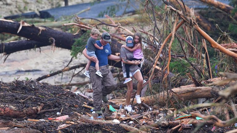 People climb over debris on a bridge atop the Guadalupe River after a flash flood. Pic: AP