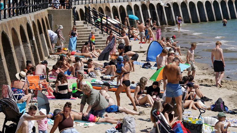 People bask in the weather on Sunny Sands beach in Folkestone, Kent. Pic: PA
