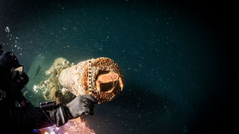 A diver uses a ruler to confirm the internal diameter of the muzzle of one of the guns on board. Pic: Steffen Scholz