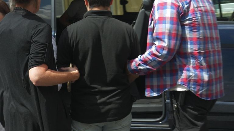 A suspected illegal immigrant working as a delivery driver being arrested