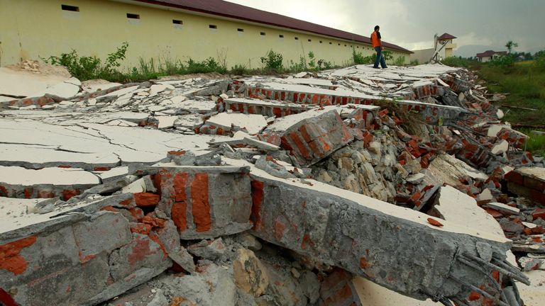 A guard walks on the ruins of prison wall which collapsed in Indonesian city of Banda Aceh in 2012 quake. Pic: Reuters