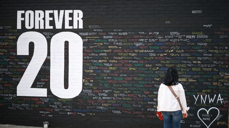 A fan looks at messages written onto a memorial wall created near Anfield Stadium. Pic: Reuters