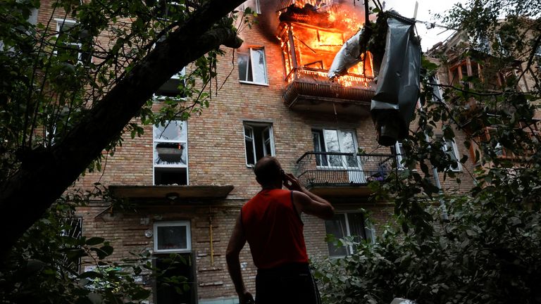 A resident looks on at the site of an apartment building hit during Russian missile and drone strikes, amid Russia's attack on Ukraine, in K