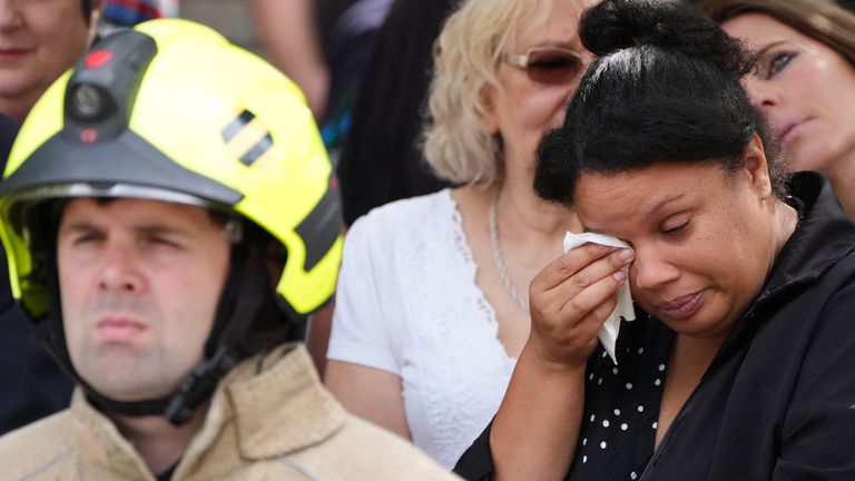 Firefighters and mourners line the street before the cortege passes Bicester Fire Station, Oxfordshire, ahead of the funeral service of Fire