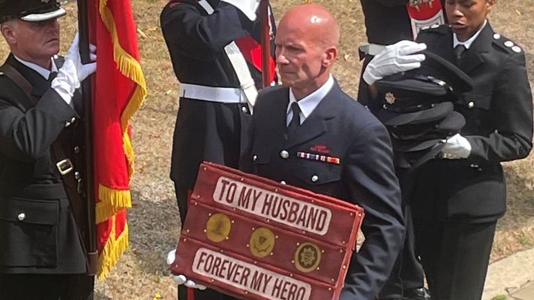 A tribute to firefighter Martyn Sadler, from his wife, is carried into St Edburg's Church in Bicester for his funeral. The firefighter lost 