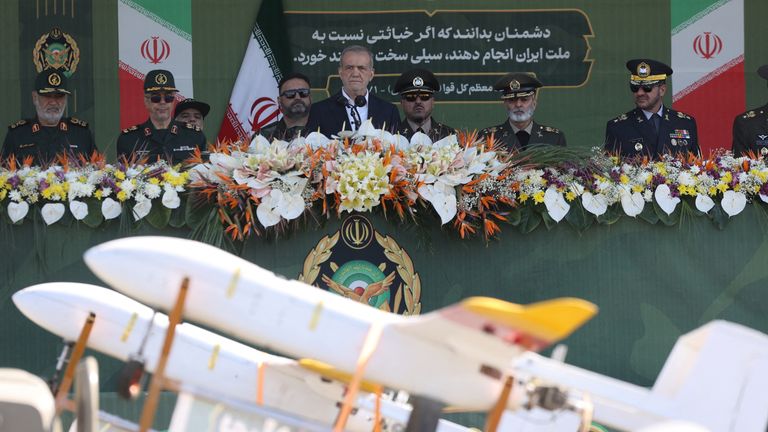 Iranian President Masoud Pezeshkian and military commanders watch as military equipment passes by during the National Army Day parade