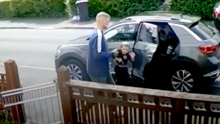 Michael Ives carrying two-year-old Ethan Ives-Griffiths outside the family home in Garden City.
Pic: North Wales Police/PA