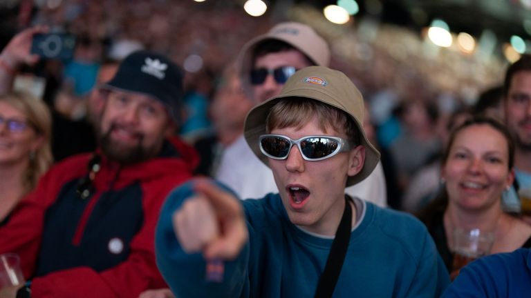 An Oasis fan is pointing at the stage during the gig. Pic: PA