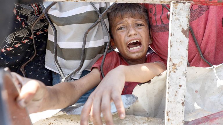 Palestinians wait to receive food from a charity kitchen, amid a hunger crisis, in Gaza City, July 24, 2025. REUTERS/Khamis Al-Rifi