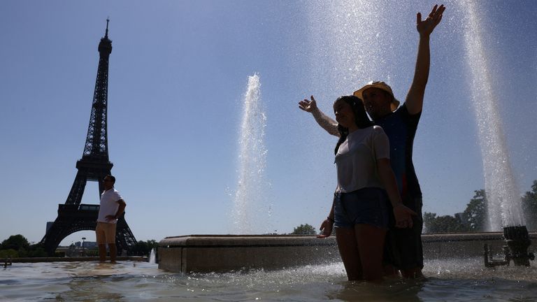 Tourists cool off in the Trocadero Fountain next to the Eiffel Tower as an early summer heatwave hits Paris, France, July 1, 2025. REUTERS/T