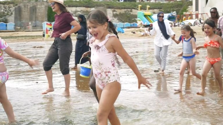 Children scream as they run into the sea