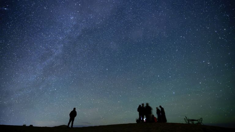 People in the Sahara desert look at the stars in the night sky outside Merzouga, Morocco December 8, 2024. Pic: Reuters