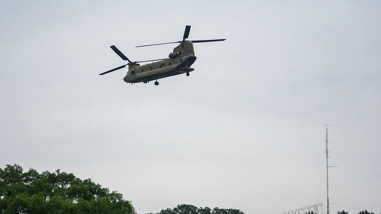 A military helicopter flies by over the Guadalupe River after a flash flood swept through the area. Pic: AP/Julio Cortez