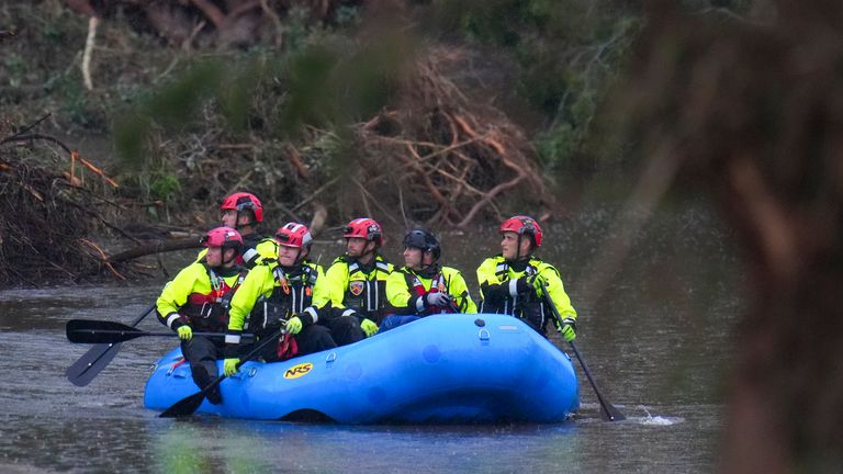 Officials ride a boat as they arrive to assist with a recovery effort at Camp Mystic. Pic: AP/Julio Cortez