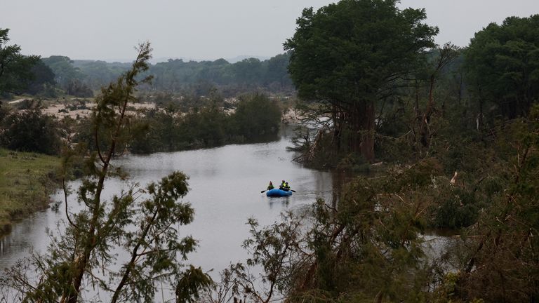 Rescuers paddle an inflatable boat as they search along a waterway following flash flooding, in Kerrville. Pic: Reuters/Marco Bello
