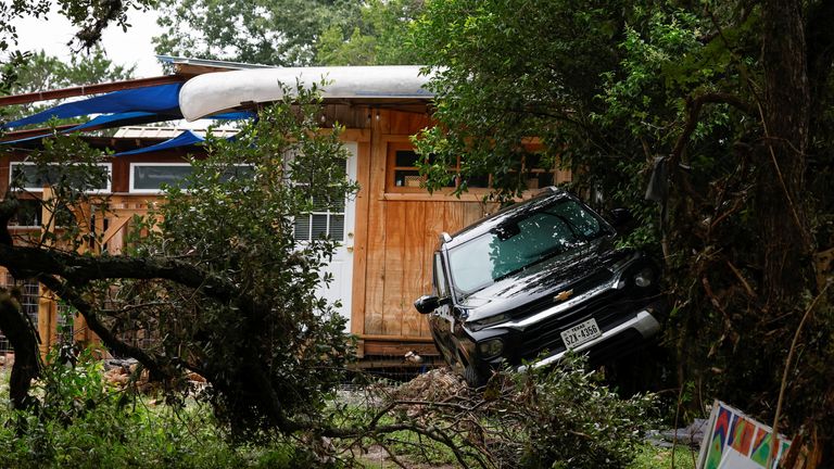 A vehicle rests against vegetation near a cabin, following flash flooding, in Hunt, Texas. Pic: Reuters/Marco Bello