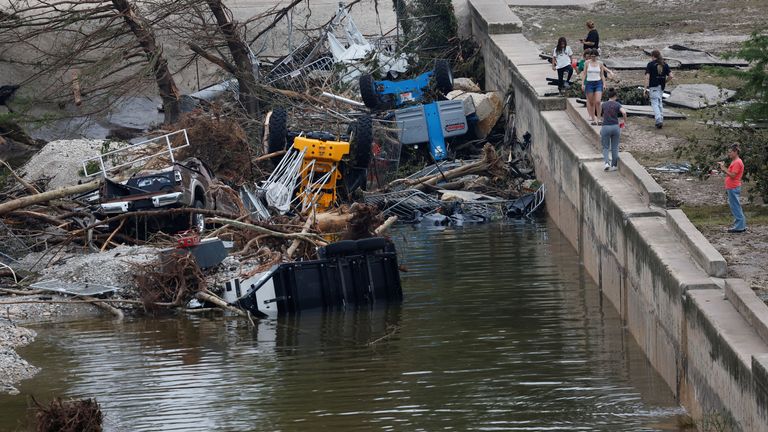 People stand near debris following flash flooding, in Kerrville, Texas, U.S. July 5, 2025. REUTERS/Marco Bello