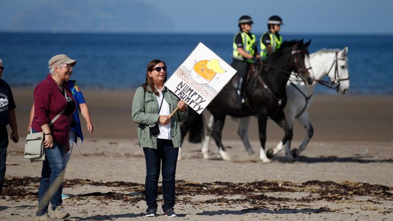 Protesters arrive on a beach near Turnberry golf club in 2018