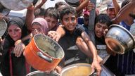 Palestinians struggle to get donated food at a community kitchen in Gaza City on 26 July. Pic: AP