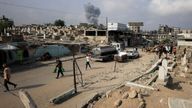 Palestinians walk past damaged graves as smoke rises following an Israeli strike, in Gaza City, August 13, 2025. REUTERS/Dawoud Abu Alkas RE