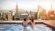 Two people take in a view of Manhattan from a rooftop pool. Pic: iStock