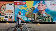A man walks past a poster celebrating the Russian Airborne Forces in the city of Melitopol, Zaporizhzhia. Pic: Reuters