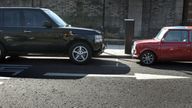 A large sports utility vehicle is seen parked next to a Mini (R) in London in this March 19, 2006 file photo. Drivers of huge Sports Utility