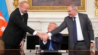 President Donald Trump, center, shakes hands with Armenian Prime Minister Nikol Pashinyan, right, and Azerbaijan President Ilham Aliyev during a trilateral signing ceremony in the State Dining Room of the White House, Friday, Aug. 8, 2025, in Washington. (AP Photo/Mark Schiefelbein)