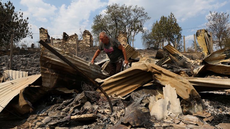 A man walks through the remains of a building on his family's property in Skenderbegas, Albania. Pic: Reuters