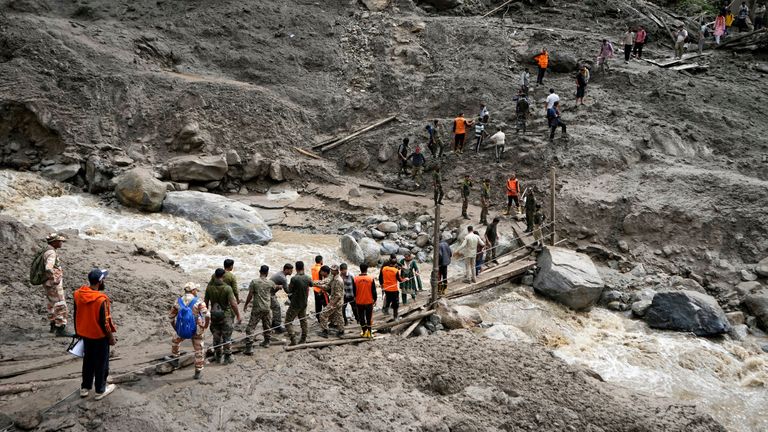 Stranded pilgrims in the village are helped to safety. Pic: AP