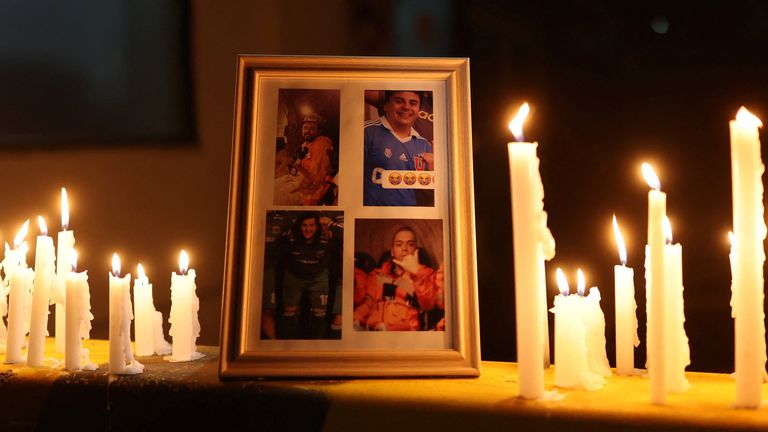 Photographs of trapped miners are shown as candles are lit during a vigil. Pic: Reuters/Pablo Sanhueza