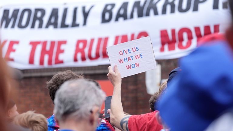 Fan Crystal Palace trzymający znak podczas marszu protestacyjnego. Zdjęcie: Pa