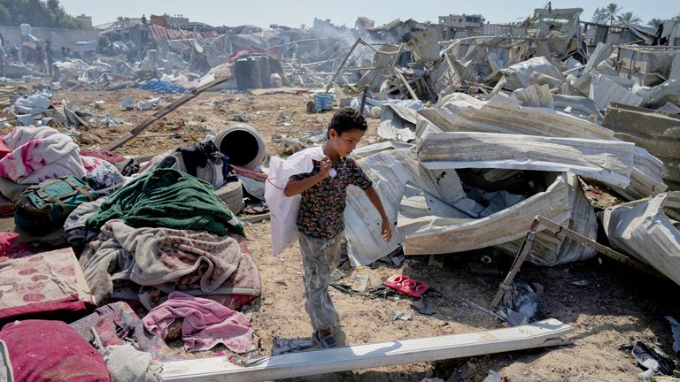 A Palestinian boy walks amid debris after strikes in Deir al Balah. Pic: AP