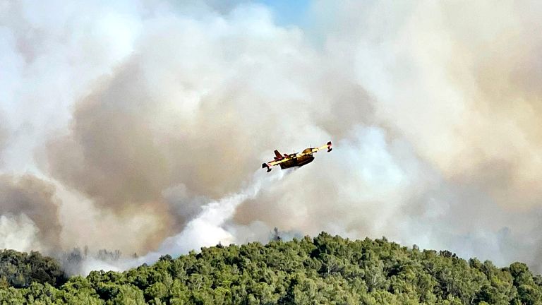 A plane drops water on the wildfire. Pic:Securite Civile/AP