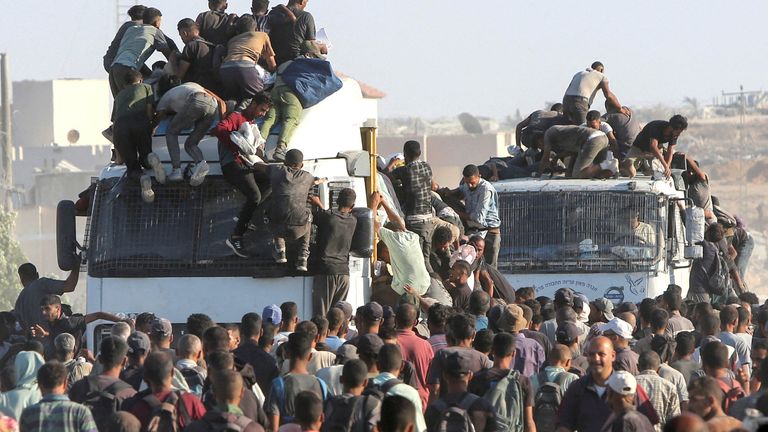 Palestinians climb onto trucks as they seek aid supplies in Khan Younis, southern Gaza Strip, August 4, 2025. REUTERS/Hatem Khaled