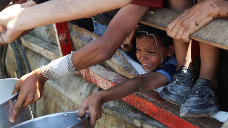 A Palestinian child waits to receive food from a charity kitchen in Gaza City. Pic: Reuters/Mahmoud Issa