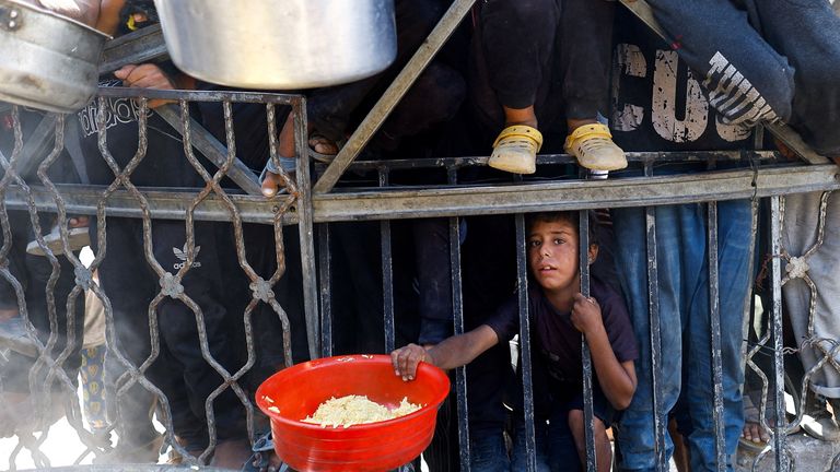A Palestinian child waits to receive food from a charity kitchen in Gaza City. Pic: Reuters/Mahmoud Issa