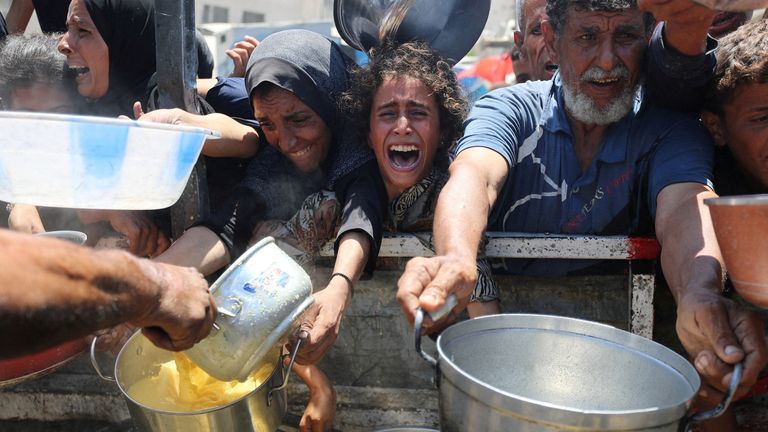 Palestinians wait to receive food from a charity kitchen, amid a hunger crisis, in Gaza City, August 2, 2025. REUTERS/Mahmoud Issa