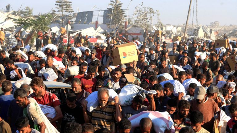 Palestinians carry aid supplies in Khan Younis, southern Gaza Strip, August 4, 2025. REUTERS/Hatem Khaled