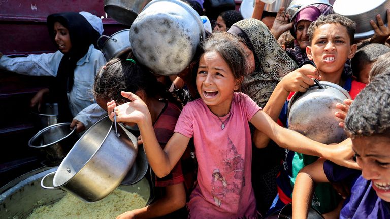 Palestinians wait to receive food from a charity kitchen in Khan Younis. Pic: Reuters