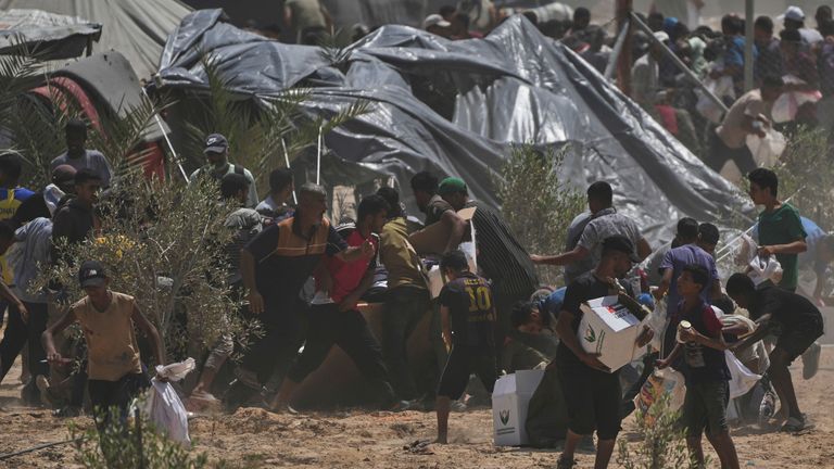 Palestinians rush to collect airdropped humanitarian aid packages. Pic: AP
