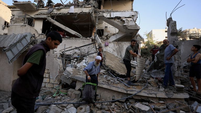 Palestinians at the site of a house struck by Israel in Gaza City. Pic: Reuters