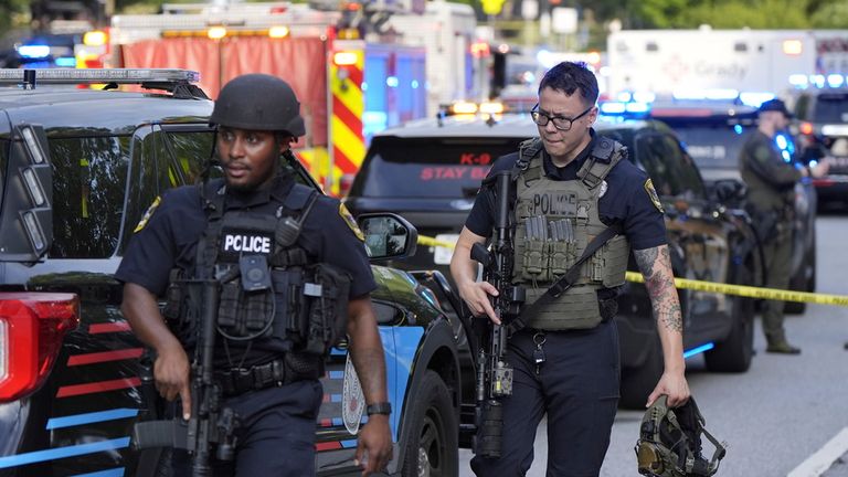 Uzbrojeni policjanci idą w pobliżu miejsca strzelania na CDC. PIC: AP