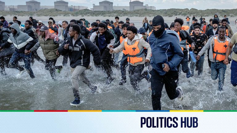 Migrants wade into the sea in an attempt to board a small boat in Gravelines, France