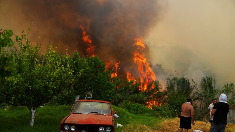 People watch a wildfire on the outskirts of Patras. Pic: Thanassis Stavrakis/AP
