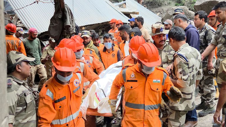 Rescue workers carry the body of a flooding victim in Chasoti, Indian Kashmir. Pic: Reuters