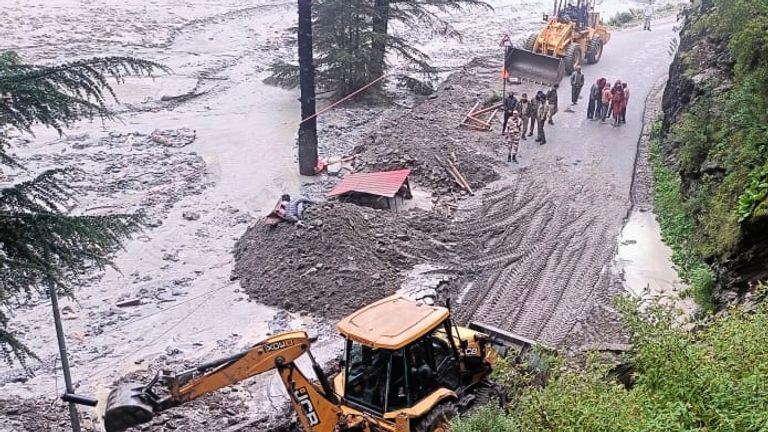 Heavy machinery is deployed to clear a road after a flash flood in Dharali, Uttarakhand, India. Pic: AP