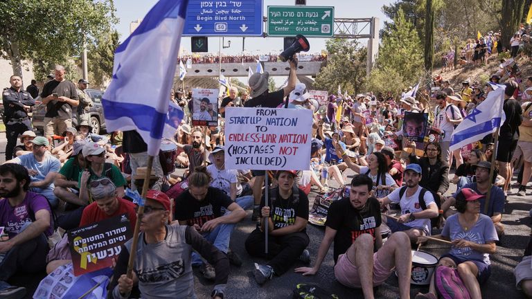 Demonstrators block a street during a protest demanding the immediate release of hostages held by Hamas and calling for the Israeli government to reverse its decision to take over Gaza City and other areas in the Gaza Strip, in Jerusalem, Sunday, Aug